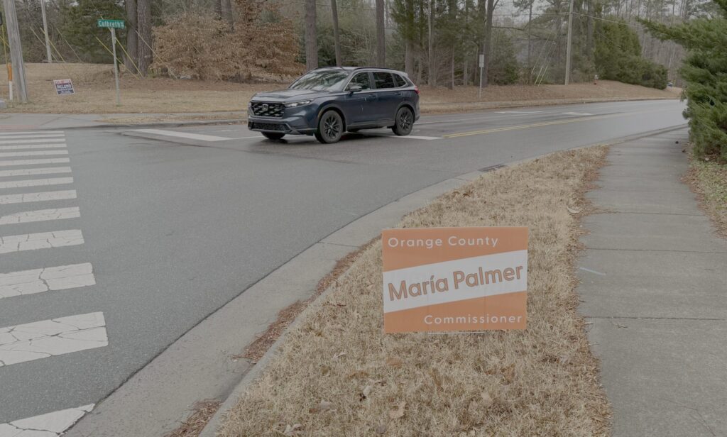 María's campaign sign at a crosswalk